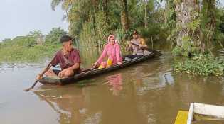 Pakai Perahu, Kapolsek Kuala Cenaku dan Salurkan Bantuan Banjir Sambil Sosialisasi Pemilu
