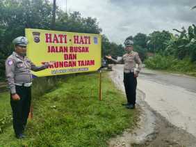 Satlantas Polres Kuansing Pasang Spanduk Peringatan di Jalan Rusak untuk Cegah Kecelakaan